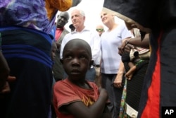 A child looks up while U.S. Sen. Bob Corker, center left, speaks to recent refugees from South Sudan at a registration center in Bidi Bidi, Uganda, April 14, 2017.
