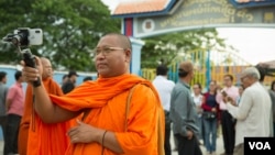 FILE - Luon Sovath, monk activist, is filming in front of Correctional Center 1 in the evening of 27th August, 2018 in Phnom Penh, Cambodia.