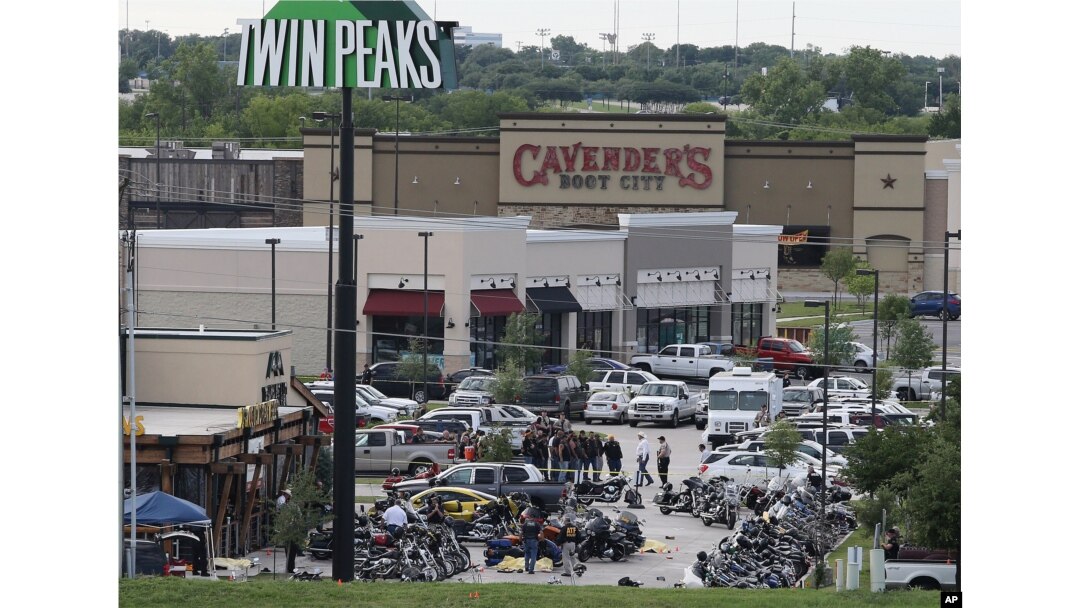 FILE - Authorities investigate a shooting in the parking lot of Twin Peaks restaurant in Waco, Texas. An indictment announced by the U.S. Attorney's Office in San Antonio accuses three Bandidos leaders of sanctioning a three-year fight that included viole