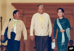 Htin Kyaw, center, newly elected president of Myanmar, walks with National League for Democracy leader Aung San Suu Kyi, right, at Myanmar's parliament in Naypyitaw, Myanmar, Tuesday, March 15, 2016.