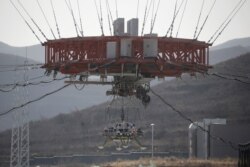 A lander hangs for a hovering-and-obstacle avoidance test for China's Mars mission at a test facility in Hebei province, China November 14, 2019. Picture taken through a window. REUTERS/Jason Lee