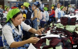 FILE - Cambodian garment workers work inside a factory in Phnom Penh.