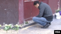 A man pays his respects to the victims of the terror attack at the Carillon bar in Paris, Nov. 15, 2015. (Photo: L. Bryant/VOA)