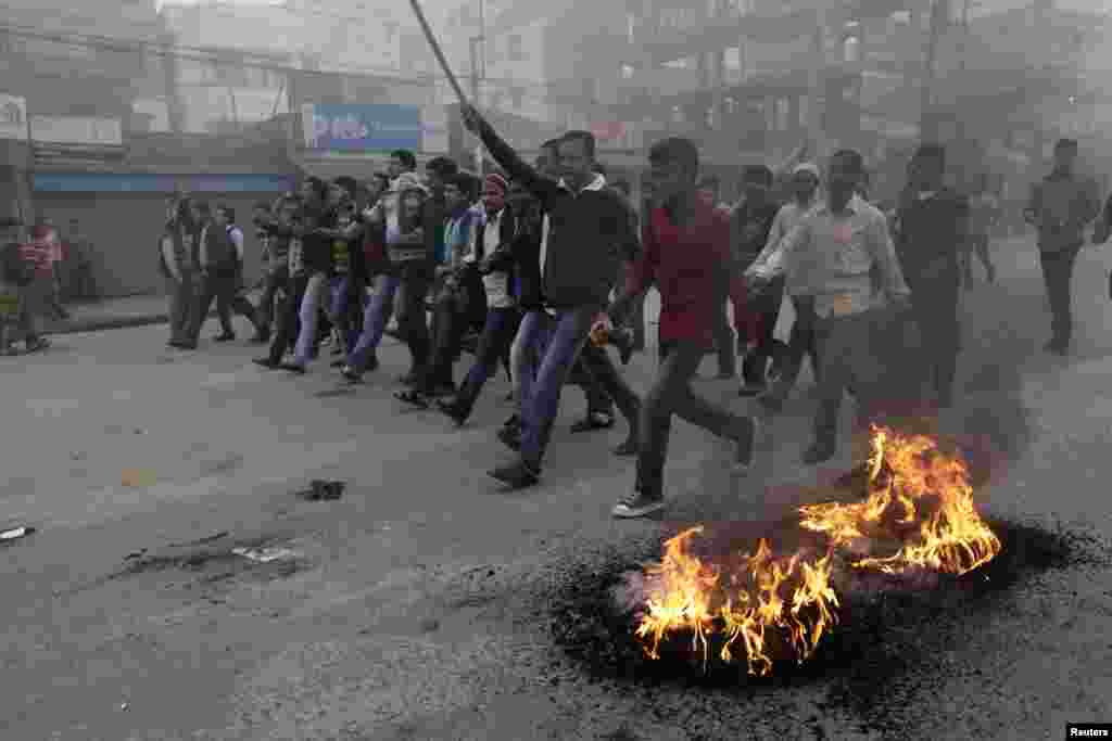 Activists of the Bangladesh Nationalist Party (BNP) shout slogans as they set fire to tyres during a nationwide blockade in Dhaka December 9, 2012. Police fired rubber bullets and tear gas to disperse protesters staging blockades across Bangladesh on Sund