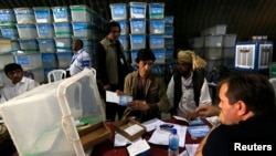 Afghan election workers count ballot papers for an audit of the presidential run-off, in Kabul, Afghanistan, Aug. 27, 2014.