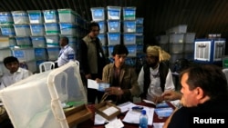 Afghan election workers count ballot papers for an audit of the presidential run-off, in Kabul, Afghanistan, Aug. 27, 2014.