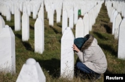 FILE - A woman visits a grave of one of her family members in the memorial center Potocari near Srebrenica, Bosnia and Herzegovina, after the court proceedings of former Bosnian Serb general Ratko Mladic, Nov. 22, 2017.