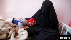 A child cries as he lays on the lap of his mother at a cholera treatment center in Sana'a, Yemen, Oct. 29, 2016. 