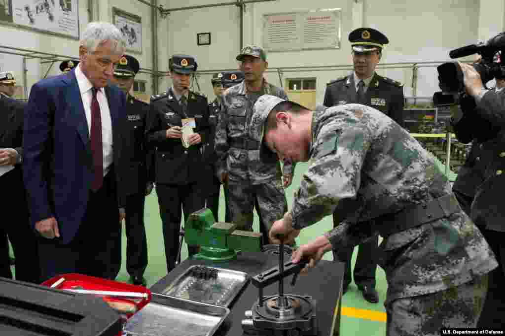 Secretary of Defense Chuck Hagel is given a tour by a Chinese military officer at the Non-Commissioned Officer Academy in Beijing, China April 9, 2014. (Department of Defense)