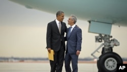 President Barack Obama is greeted by Chicago Mayor Rahm Emanuel upon his arrival on Air Force One at O'Hare International Airport in Chicago, Oct. 25, 2012. 