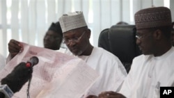 Attahiru Jega, Independent National Electoral Commission Chairman, reads the results sheet before he declared Nigeria's incumbent President Goodluck Jonathan as the winner of last Saturday's presidential election.