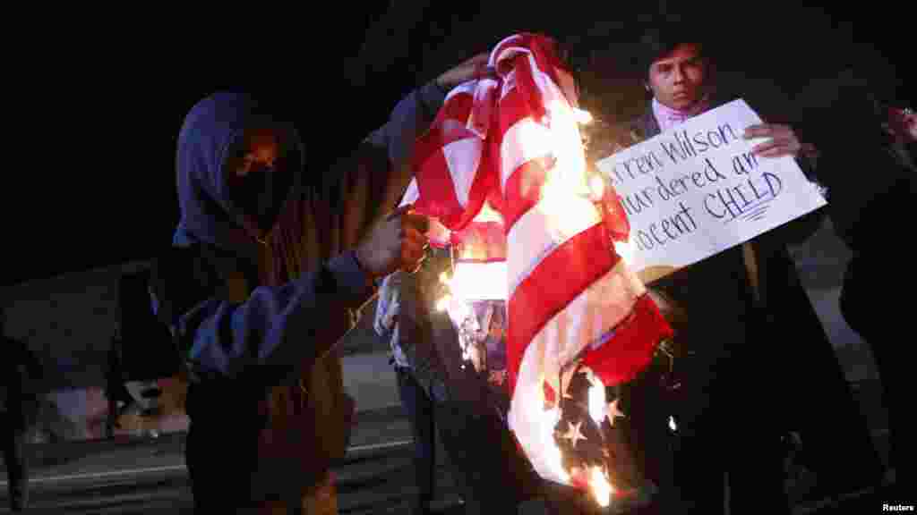 Un manifestant brûle un drapeau américain sur l&#39;autoroute 580 lors d&#39;une manifestation après la grande décision du jury dans la fusillade de Michael Brown, à Oakland, en Californie, le 24 novembre 2014.