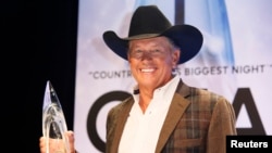 George Strait poses backstage with his Entertainer of the Year award at the 47th Country Music Association Awards in Nashville, Tennessee, Nov. 6, 2013.