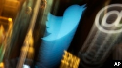 FILE -The Twitter logo appears on a phone post on the floor of the New York Stock Exchange.
