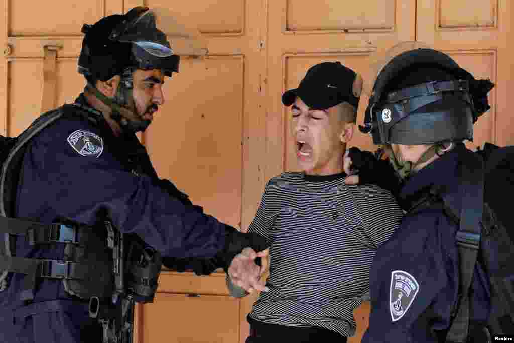 Israeli border police members detain a Palestinian during a protest against Israel's plan to annex parts of the occupied West Bank, in Heron.