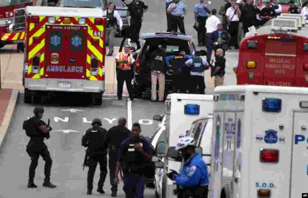 Emergency vehicles and law enforcement personnel respond to a shooting at an entrance to the Washington Navy Yard, Sept. 16, 2013.