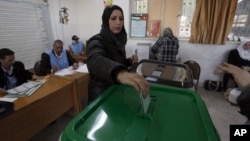 A woman casts her vote at a polling station during the first hours of the Jordanian Parliamentary elections, in Al-Salt, Jordan, January 23, 2013.