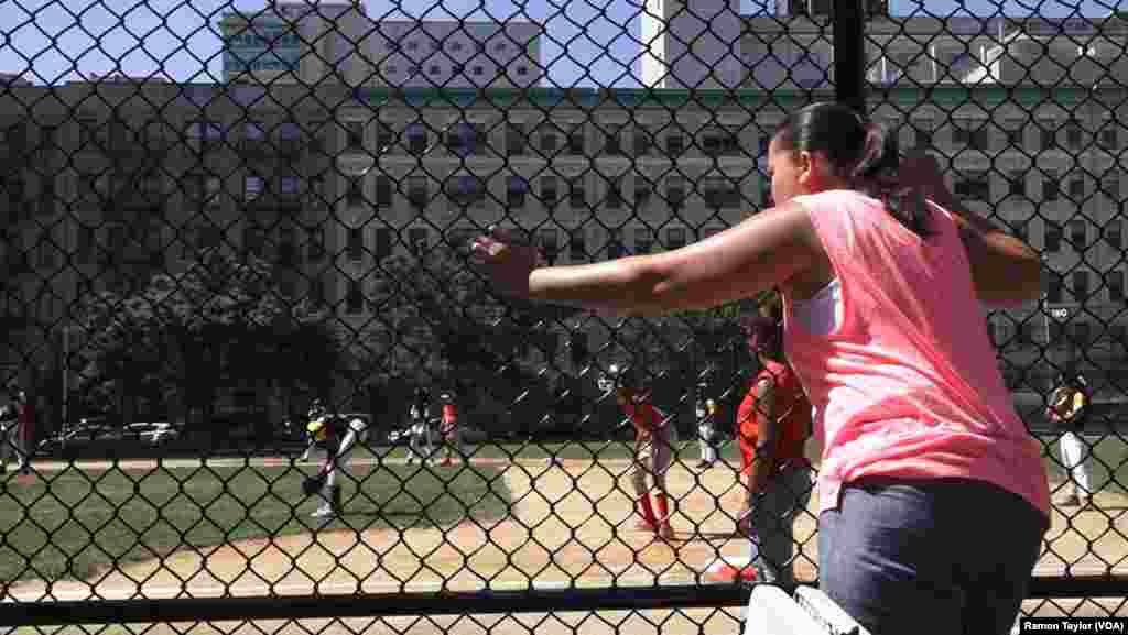 An East Harlem supporter cheers on members of the Doshi Peaches, who won their championship game against the South Bronx Red Wings, 9-6, in New York, Aug. 12, 2016.