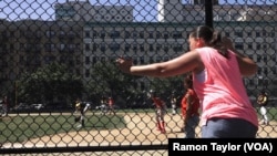 An East Harlem supporter cheers on members of the Doshi Peaches, who won their championship game against the South Bronx Red Wings, 9-6, in New York, Aug. 12, 2016.