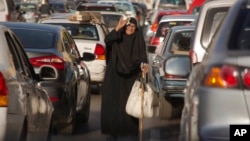 FILE -- An Egyptian vendor looks for clients amid a traffic jam in Cairo, Nov. 7, 2016. Social media, TV stations and newspapers in Egypt are abuzz after reports that the country's parliament speaker and his two deputies are using state funds to get flashy cars worth hundreds of thousands of dollars.