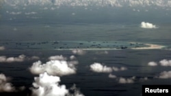 FILE - An aerial photo taken though a glass window of a Philippine military plane shows the alleged ongoing land reclamation by China on mischief reef in the Spratly Islands in the South China Sea, west of Palawan, Philippines.