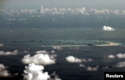 FILE - An aerial photo taken though a glass window of a Philippine military plane shows the alleged ongoing land reclamation by China on mischief reef in the Spratly Islands in the South China Sea, west of Palawan, Philippines.