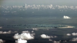 An aerial photo taken though a glass window of a Philippine military plane shows the alleged ongoing land reclamation by China on mischief reef in the Spratly Islands in the South China Sea, west of Palawan, Philippines.