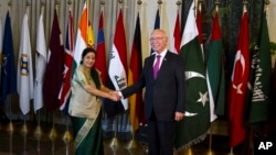 Indian Foreign Minister Sushma Swaraj (L) shakes hand with Pakistan's top adviser for foreign affairs, Sartaj Aziz, prior to their meeting in Islamabad, Pakistan, Dec. 9, 2015.