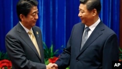 10일 중국 베이징의 인민대회당에서 아베 신조 일본 총리(왼쪽)와 시진핑 중국 국가주석이 만나 악수하고 있다.