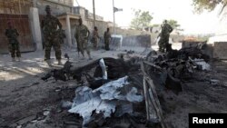 Somali government soldiers secure the scene of a suicide attack next to the gate of the Presidential Palace in Mogadishu February 21, 2014. 