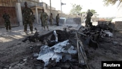 Somali government soldiers secure the scene of a suicide attack next to the gate of the Presidential Palace in Mogadishu on February 21, 2014.