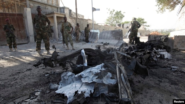 Somali government soldiers secure the scene of a suicide attack next to the gate of the Presidential Palace in Mogadishu, Feb. 21, 2014. 