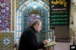 Iran's Parliament Speaker Ali Larijani votes in the parliamentary and Experts Assembly elections at a polling station in Qom, 125 kilometers (78 miles) south of the capital Tehran, Iran, Feb. 26, 2016.