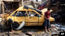 2月8日一名男孩站在一部受到炸彈襲擊毀壞不堪的汽車旁。
