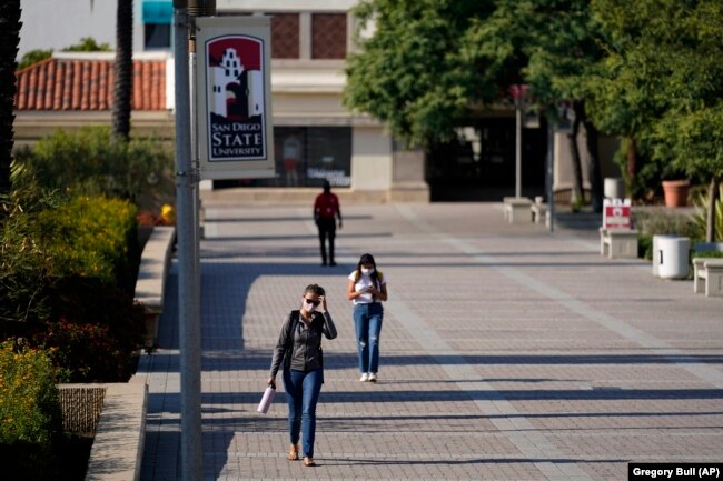 FILE - In this Sept. 2, 2020 file photo people walk on campus at San Diego State University, in San Diego. (AP Photo/Gregory Bull,File)