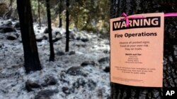 FILE - A notice warns visitors of controlled-fire operations in Kings Canyon National Park, Calif., Oct. 30, 2017.