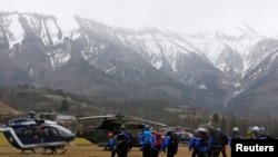 French Police and Gendarmerie Alpine rescue units gather on a field as they prepare to reach the crash site of an Airbus A320, near Seyne-les-Alpes, in the French Alps, March 24, 2015.