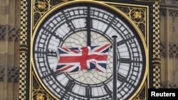 A British Union flag flutters in front of one of the clock faces of the 'Big Ben' clocktower of The Houses of Parliament in central London, Feb. 22 , 2016