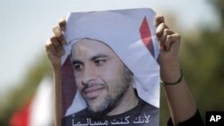A mourner holds up a portrait of Abdulrassul Hujairi during his funeral in the village of Buri outside Manama on March 21, 2011