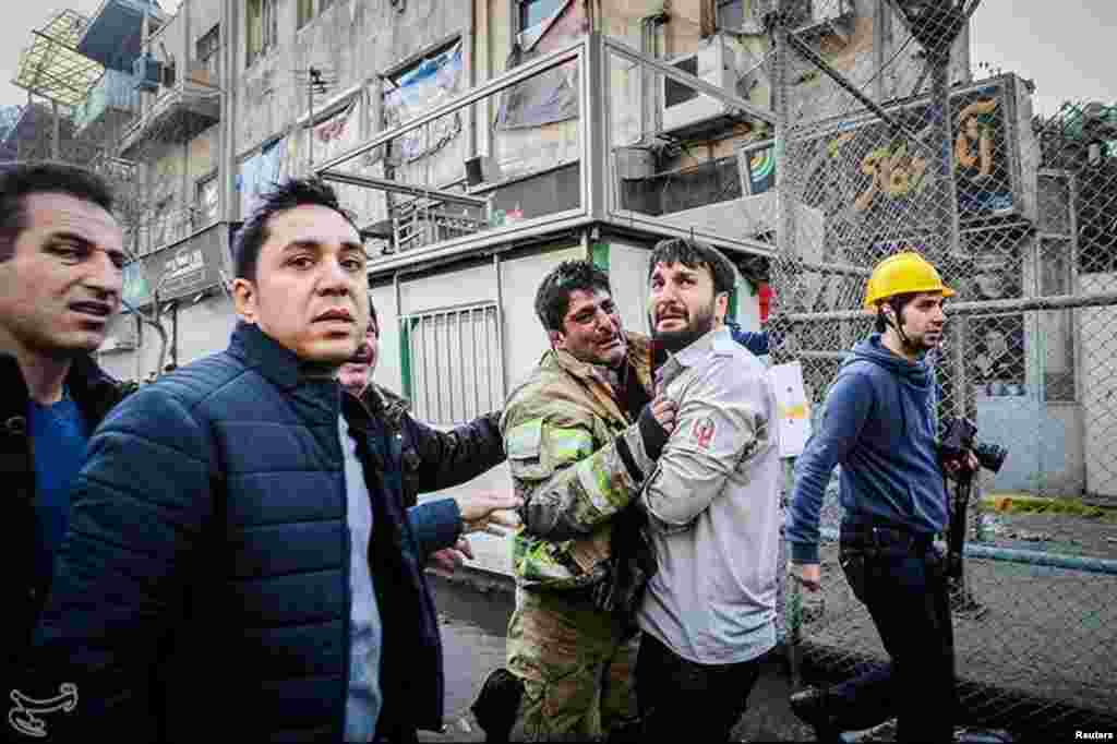 A firefighter reacts at the site of a collapsed high-rise building in Tehran, Iran.