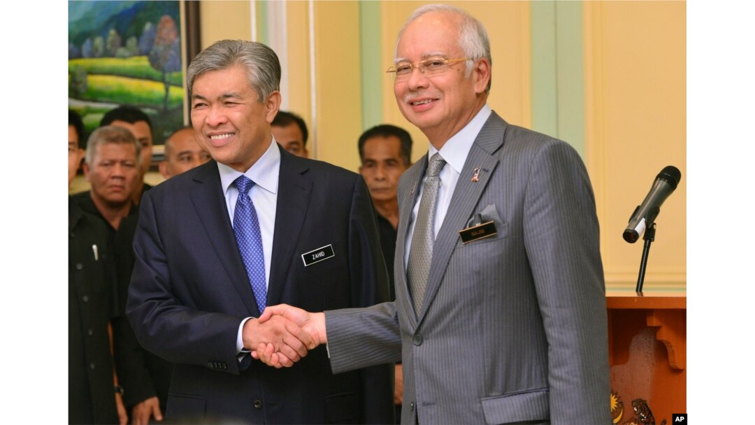 Perdana Menteri Malaysia Najib Razak, kanan, berjabat tangan dengan Wakil Perdana Menteri yang baru dilantik Ahmad Zahid Hamidi setelah berpidato pada konferensi pers di kantor perdana menteri di Putrajaya, Malaysia, 28 Juli 2015. (Foto: AP)