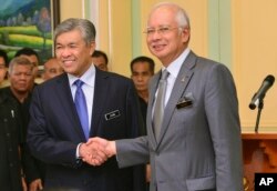 Perdana Menteri Malaysia Najib Razak, kanan, berjabat tangan dengan Wakil Perdana Menteri yang baru dilantik Ahmad Zahid Hamidi setelah berpidato pada konferensi pers di kantor perdana menteri di Putrajaya, Malaysia, 28 Juli 2015. (Foto: AP)