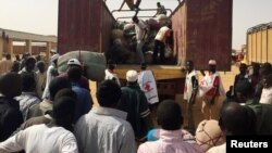 Para migran yang dideportasi dari Aljazair mengambil barang-barang mereka di Agadez, Niger. 