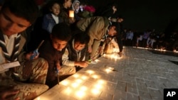 Jordanians light candles that form the Earth Hour logo, in an official attempt to be registered in the Guinness Book of Records for the largest candle-shaped World Hour logo, in Amman, Jordan, March 24, 2018.