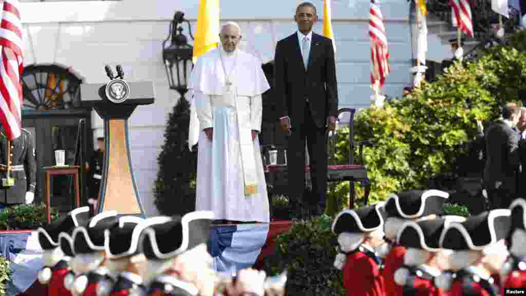 President Barack Obama and Pope Francis watch onstage as the &quot;Old Guard&quot; fife and drum corps marches past during an official welcome ceremony of the South Lawn at the White House, Sept. 23, 2015.