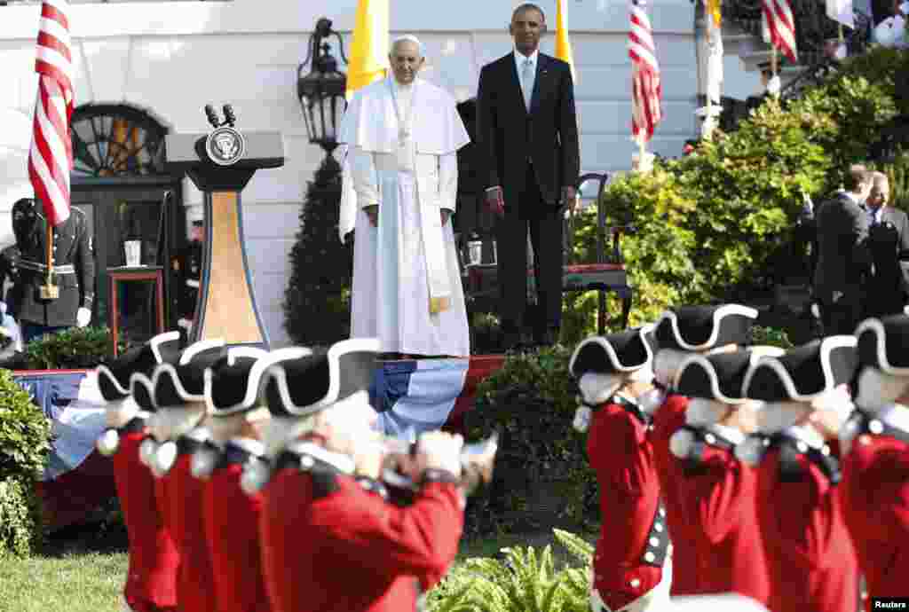 President Barack Obama and Pope Francis watch onstage as the &quot;Old Guard&quot; fife and drum corps marches past during an official welcome ceremony of the South Lawn at the White House, Sept. 23, 2015.