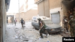 Forces loyal to President Bashar al-Assad are seen at Suleiman al-Halabi neighborhood in Aleppo, Syria, September 20, 2012. 