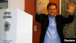 FILE - Senator Marcelo Crivella, candidate for Rio de Janeiro mayor, gestures to photographers after voting during the municipal elections at a polling station in Rio de Janeiro, Brazil, Oct. 30, 2016.