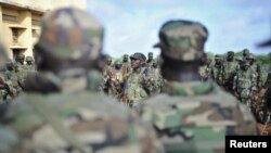 FILE - Troops from the African Union Mission in Somalia (AMISOM) gather for a briefing in Somalia, Oct. 18, 2012. Five African Union peacekeepers in Somalia were arrested for allegedly trying to sell military supplies.