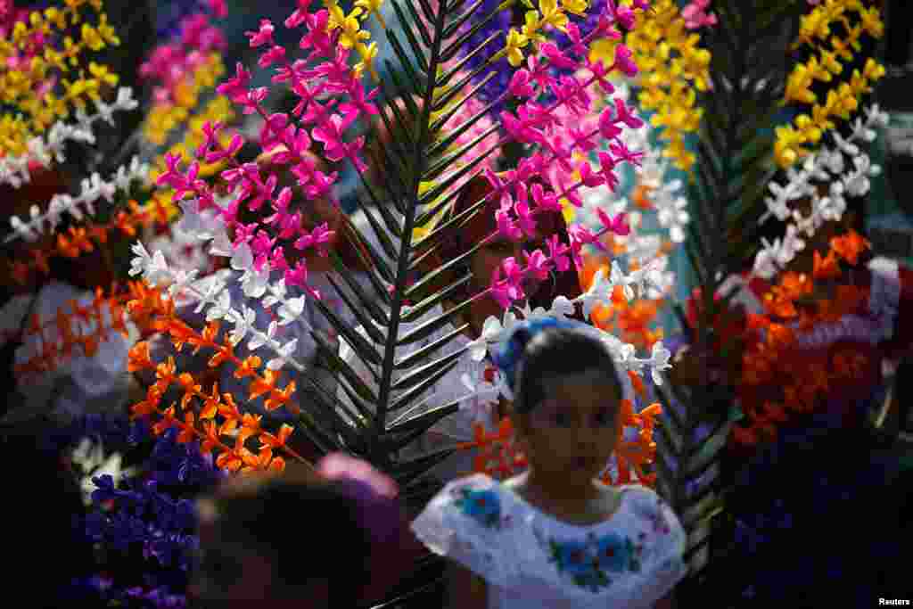 Girls dressed in traditional costumes take part in the festivity of the Holy Cross to ask for a good rainy season in Panchimalco, El Salvador.